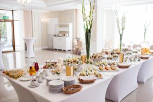 波德拉谢地区别尔斯克Hotel Cztery Pory Roku的一张长长的白色桌子,上面有食物