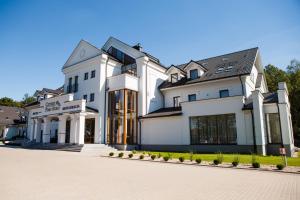 波德拉谢地区别尔斯克Hotel Cztery Pory Roku的一座带车道的大型白色房屋