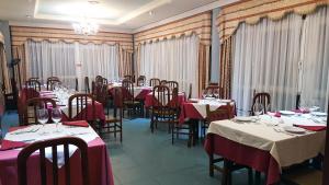 比利亚丹戈斯德尔帕拉莫Hotel Avenida III的一间带桌椅和红色桌布的用餐室