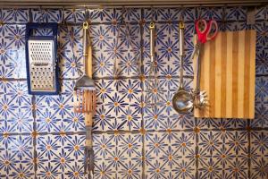 恩纳La Casa Sulla roccia的墙壁上用蓝色和白色瓷砖装饰,配有餐具