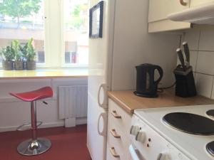 哥德堡林奈酒店的厨房配有炉灶和红色凳子