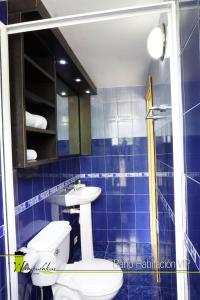 ZamoraHotel Wampushkar的蓝色瓷砖浴室设有卫生间和水槽