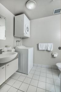 奥克兰皇冠辛特拉莱恩公寓的白色的浴室设有水槽和卫生间。