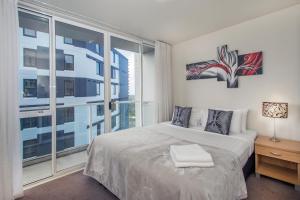 奥克兰皇冠辛特拉莱恩公寓的一间卧室设有一张床和一个大窗户