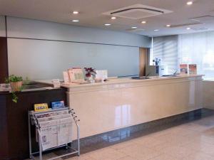 Okaya冈谷市中央大酒店 的大堂设有柜台和现金登记册