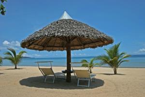 MadirokelyEden Lodge的海滩上的两把椅子和一把遮阳伞