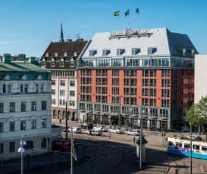 哥德堡ProfilHotels Opera的一座大型红色建筑,在城市里,有汽车