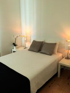 里斯本LX Factory Apartment 1的一间卧室配有一张带两盏灯的大型白色床。