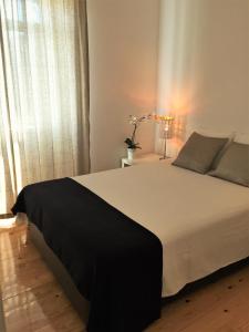 里斯本LX Factory Apartment 1的卧室设有一张白色大床和一扇窗户。