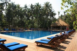 丹格迪维拉蔓豪岛度假酒店的一个带躺椅的大型游泳池,棕榈树
