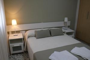博罗尼亚Apartamentos Bolonia Paraiso的酒店客房,设有床铺和2个床头柜
