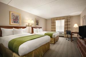 夏洛特夏洛特大学江山旅馆与套房酒店的酒店客房设有两张床和电视。