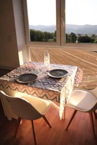 蒙特利马尔La Colombière - Montélimar的一张桌子、两把椅子和一张桌子及两个盘子