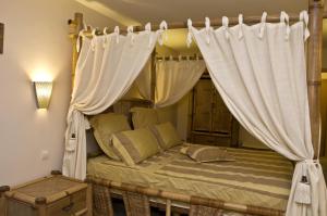索非亚佐娜酒店4号的卧室配有带白色窗帘的天蓬床