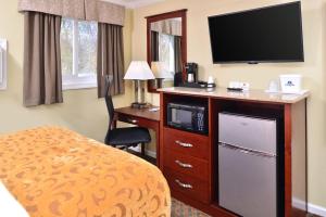 柴郡柴郡欢迎旅馆的酒店客房设有电视、床和书桌