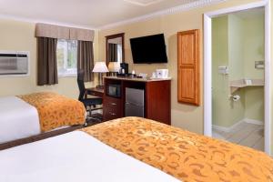 柴郡柴郡欢迎旅馆的酒店客房设有两张床和一台平面电视。