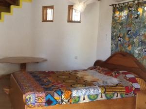 NdanganeCampement Le Cormoran的一间卧室配有一张带彩色毯子的床