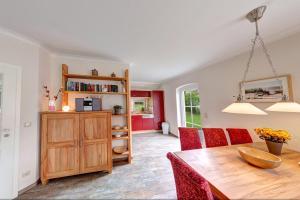 StubbenfeldeReetdachhaus Seeblick的一间带木桌和红色椅子的用餐室