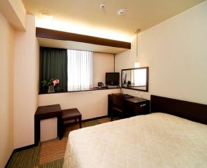 新泻新泻市酒店 的配有一张床、一张书桌和一扇窗户的酒店客房