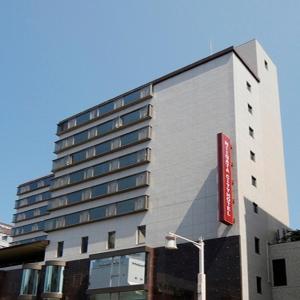 新泻新泻市酒店 的一座高大的建筑,上面有红色的标志