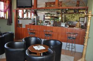 卢巴夫卡Zajazd Magrani的酒吧配有黑色皮椅和桌子