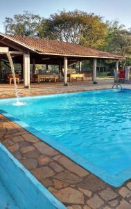 莫科卡Pousada Fazenda Buracão的一个带喷泉的大型蓝色游泳池