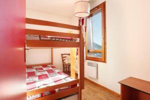 圣费朗索瓦-隆尚Résidence Odalys Belle Vue的一间卧室配有双层床和窗户。