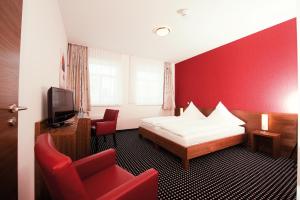 哈伦格瑞酒店的酒店客房,设有床铺和红色的墙壁