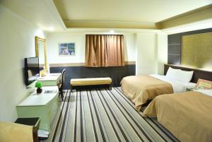 桃园市樱珍大饭店的酒店客房配有两张床和一张书桌