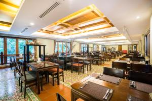 纳仲天朵沙达海洋度假村的餐厅设有木桌、椅子和窗户。