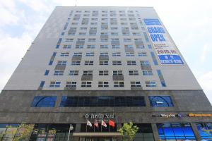 首尔城际首尔酒店 的一座高大的白色建筑,上面有标志