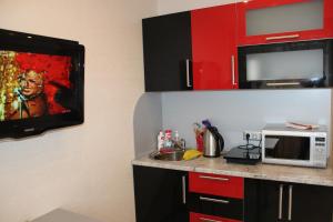 季赫温Apartments 4 Mikrorayon的带微波炉的厨房和电视