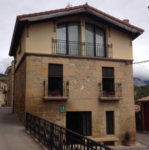 比利亚布纳德阿拉瓦Casa Rural Baigorrietxea的一座带窗户和阳台的古老石头房子