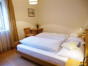 菲耶Apartment Weissenegger的一间卧室配有两张带白色床单的床
