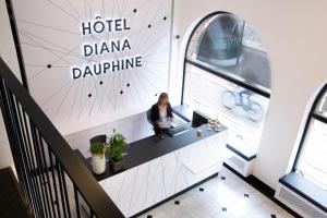 斯特拉斯堡Hôtel Diana Dauphine的坐在药剂学肾上腺素旅馆桌子上的女人