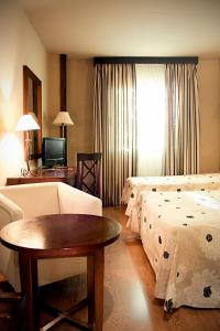 迪拉尔Hotel Zerbinetta的客厅配有两张床和一张桌子