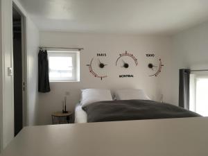 鲁昂Le Dix-Huit Studio Duplex的卧室配有床和墙上的时钟