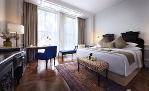 雅加达古纳瓦尔曼酒店 的一间带一张大床和一张书桌的卧室和一间房间