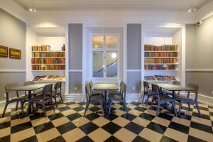 罗斯基勒Zleep Hotel Prindsen Roskilde的图书馆配有桌椅和书架