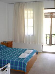 卡亚克狂想曲别墅膳食公寓的卧室配有蓝色和白色的床和窗户。