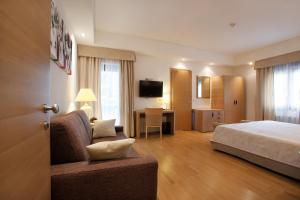 San Giovanni al NatisoneHotel Campiello的酒店客房设有床和客厅。
