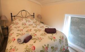 阿伦德尔The Old Chapel的一间卧室配有一张带花卉床罩的床