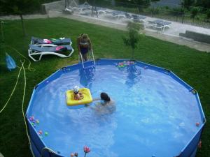 Asín de Broto公证处酒店的两人在游泳池里,一个儿童在木筏里