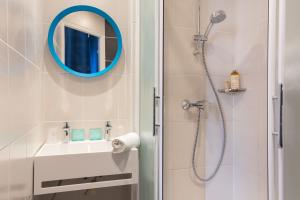 尼斯Hostel Ozz Nice的设有带镜子和水槽的淋浴的浴室