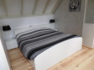 GasselteB&B Huize Cossee的铺有木地板的白色床铺