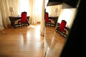 纽伦堡德尔瑞本酒店的一间设有红色椅子和一张桌子及窗户的房间