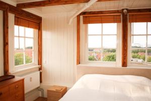 哈林亨Het Dakhuis的卧室配有白色的床和窗户。