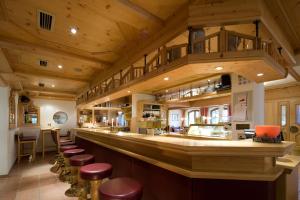 瑟尔艾尔朋潘纳洛马酒店的餐厅内的酒吧设有木制天花板和凳子