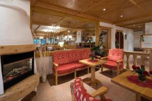 瑟尔艾尔朋潘纳洛马酒店的客厅配有红色椅子和壁炉
