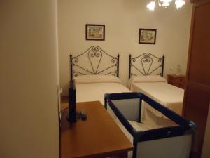MollinaHotel Antequera Rural Fortes La Nuit的一间卧室配有两张床、一张桌子和一张桌子